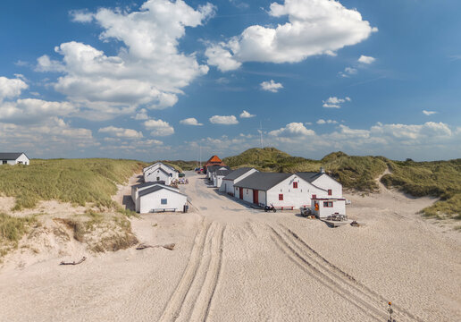 Aerial view of Stenbjerg, North Jutland, Denmark. Fishing village with classic white fishermen&rsquo;s huts, sandy beaches, dunes, and the North Sea coastline, iconic summer landscape in Thy National Park