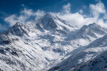 Obraz premium Snow-covered majestic mountain peak towering above surrounding ranges