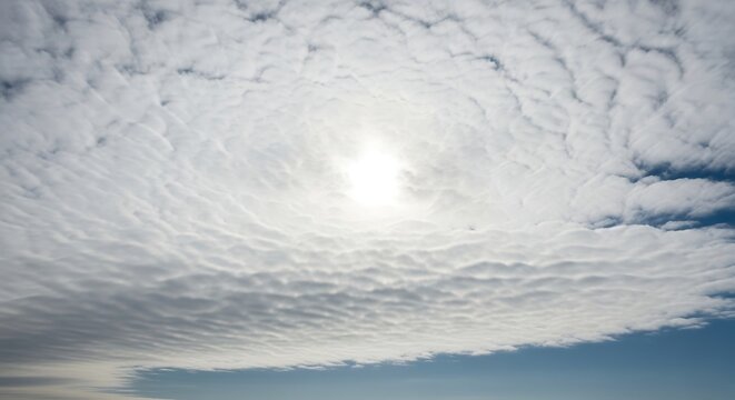 Expansive altocumulus clouds with a radiant sunburst illuminating the atmosphere
