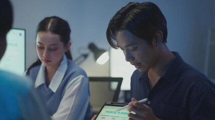 Business professionals interact with a laptop and tablet, exchanging ideas on budgeting, communication and digital transformation.