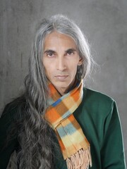 Fashionable young man wearing flannel scarf in studio pose.