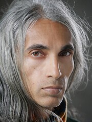 Headshot of a middle eastern man with long hair