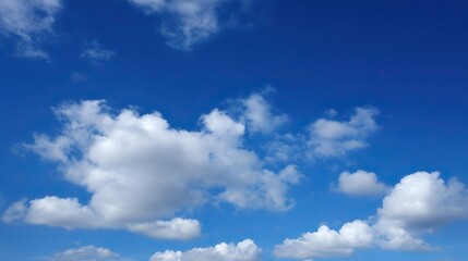 Fototapeta premium There are little white clouds in the beautiful blue sky, with plenty of blank space, showcasing exquisite details, suitable for various uses.