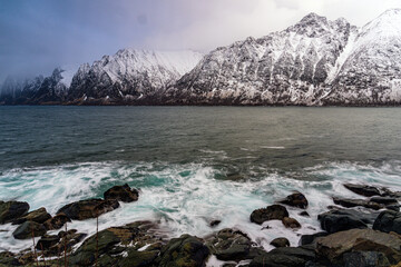Snow-Covered Mountains by the Arctic Sea with Rocky Shoreline