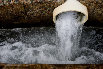 Wastewater Discharge from Industrial Drain Pipe into Sewer System