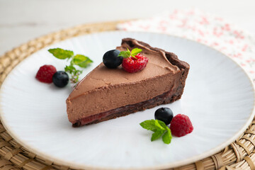 Chocolate mousse cake with red berries, blueberries, and raspberries.