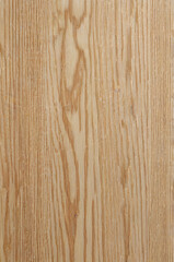 Fototapeta premium This image shows a natural wooden surface with a distinct and bold grain pattern. The wood has a warm beige tone with dark brown lines forming wavy, organic shapes along the length.