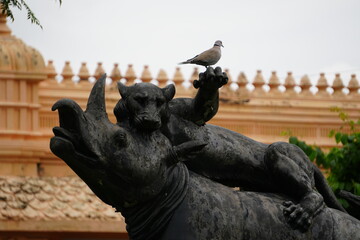 A dramatic stone statue showing a fierce beast in a grappling pose with a boar