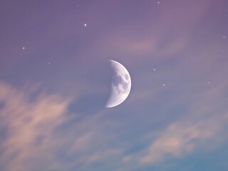 Crescent moon glowing in a soft purple and pink sky with wispy clouds