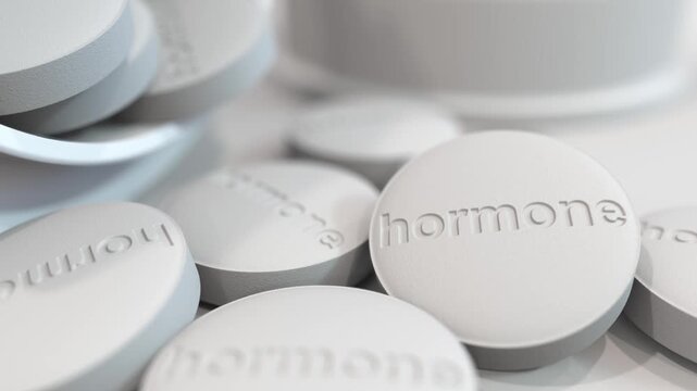Close-up video of hormone tablets with embossed text, representing hormone therapy, medication, supplements, and endocrine treatment for healthcare and wellness.