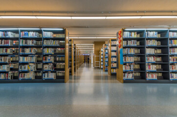 Obraz premium Blurred background of quiet library bookshelves and aisles.