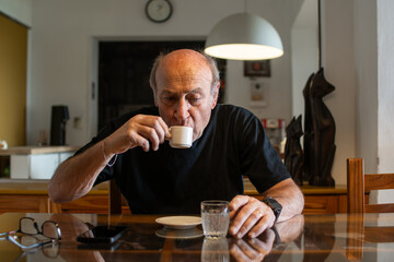 Hombre mayor pensativo tomando café