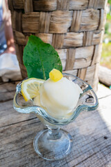 Refreshing lemon sorbet served in a glass cup on a rustic wooden table along the Path of Lemons, Amalfi Coast, Italy – a taste of Mediterranean summer.