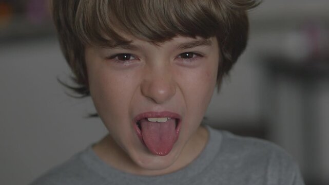 Young Boy Showing Tongue Making Fooling Around, Teasing. Tongue Out Child Grimacing Kid. Angry Boy Shows Her Tongue in Funny Grimace. Bad Behavior of Children.