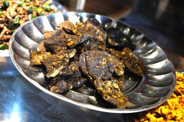 Close-up of Dark, Crispy Food in a Silver Bowl