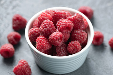 Fresh organic farm raspberries in bowl, closeup view. Juicy summer berries