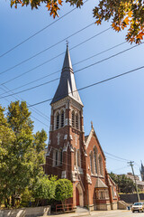 Victorian style architecture red brick church tower against blue sky