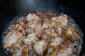 Cooking recipe for cooking meat in a cast-iron cauldron outdoors. Cooking food. Frying meat.