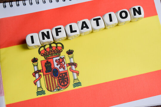 Inflation on stacked wooden cubes with Spanish flag on the table. Business and finance concept