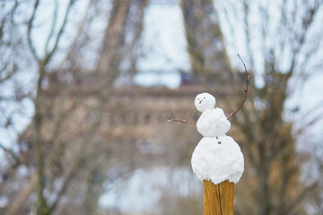 little snowman and the Eiffel tower on a day with heavy snow