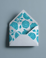Open white envelope with a beautiful turquoise floral pattern liner.