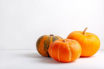 Three pumpkins on a white background. Copy space