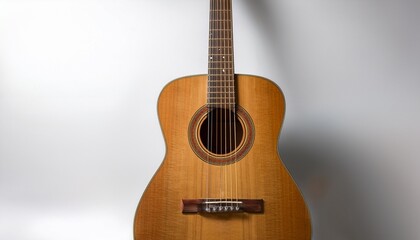 Obraz premium a brown wooden acoustic guitar rests alone on a white background