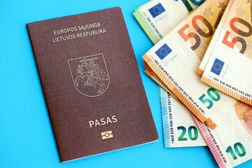 Lithuania passport lies with euro money banknotes on blue background. Salary and pension in Europe