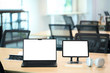 Laptop and tablet with blank screens on a shared desk