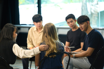 Support group therapy session with diverse young adults sharing experiences and offering encouragement