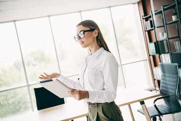 Confident businesswoman presenting a project in a modern office interior during a professional workspace meeting