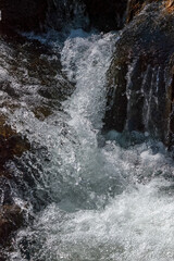 Rushing Stream over Sunlit Rocks