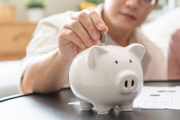 Happy asian family young couple love hand holding piggy bank to save and model house for saving money wealth to buy real estate for new home. Financial planning, business finance concept. Housing loan