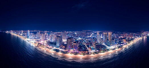 Aerial view Panorama of night cityscape with skyscraper neon light Nha Trang city Vietnam and bay of Sea.