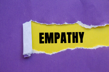 Empathy message written on ripped torn purple paper on yellow background. Conceptual Empathy...