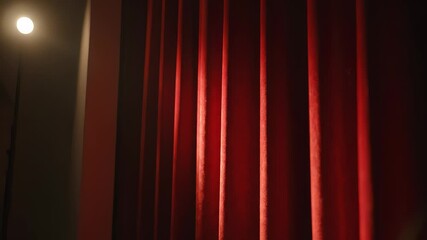 Dramatic red curtains illuminated by soft light, showcasing texture and depth, creating an inviting atmosphere for a theatrical performance or event