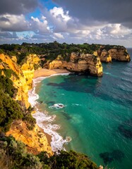 Dramatic coastal view, golden cliffs, turquoise sea