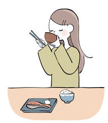 お味噌汁を飲む女性