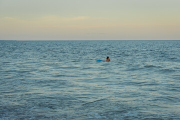 surfer in the ocean at sunset