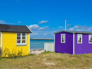 Explore the vibrant and colorful beach huts situated right by the serene sea shore