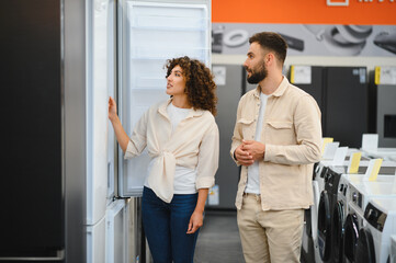 Fototapeta premium Couple exploring home appliances in electronics store