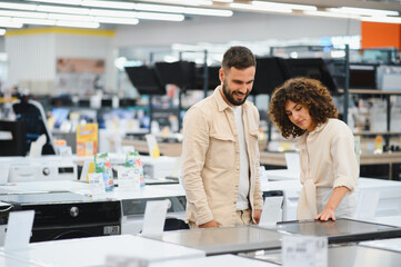 Obraz premium Couple exploring home appliances in electronics store