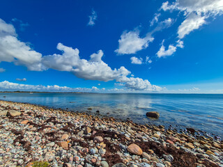 Enjoy a tranquil seaside view with fluffy clouds and clear waters, perfect for relaxation