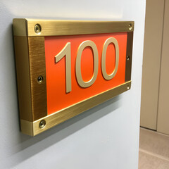 a gold and orange sign that says 100
