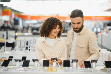 Couple choosing new smartphone in electronics store