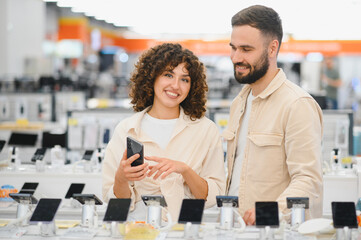 Couple choosing smartphone in electronics store
