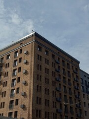 Obraz premium A captivating view of a beautiful brick building with unique urban architecture against a dramatic sky.