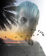 Double exposure portrait of adult male with serious expression blended with sunset