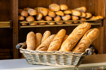 Fresh baguettes in basket at traditional bakery shop