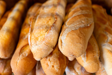 Freshly baked baguettes pile in a bakery display